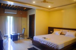 a bedroom with a bed and a chair in it at PRINCE PALACE in Jhārgrām