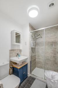 a bathroom with a shower and a sink and a toilet at Stunning Family Friendly Home - Free Parking in Bedford