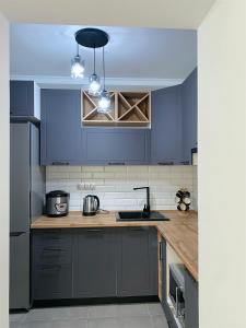 a kitchen with blue cabinets and a counter top at Квартира на берегу Черного моря in Sukhum