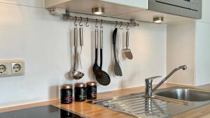 cocina con fregadero y utensilios en la pared en Villa Sonneck – Wohnung 15 en Ostseebad Sellin