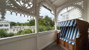 a gazebo with a bench on a porch at Villa Sonneck – Wohnung 15 in Ostseebad Sellin