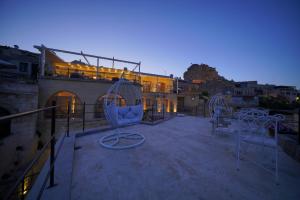 um pátio no último piso com cadeiras e um edifício em Karlık Cave Suite Cappadocia em Üçhisar