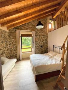 - une chambre avec un grand lit et une fenêtre dans l'établissement Encuentra el norte en la Casa del buen camino, à Oreña