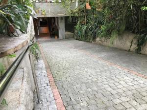 a brick walkway with a building and plants at Casa Dona Hilda Blumenau in Blumenau