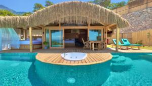 a resort with a pool and a room with a bed at Seaview Faralya in Faralya