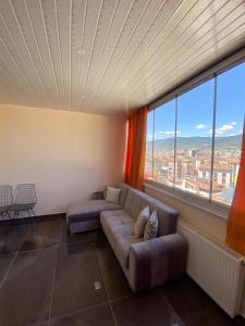a living room with a couch and a large window at dagkent plus suit in Tokat