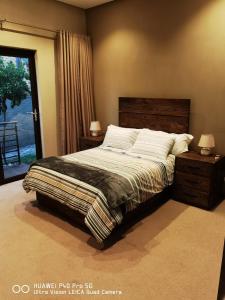 a bedroom with a bed with two night stands and a window at Tramonto Guesthouse in Parys