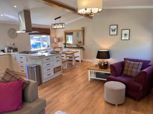 uma cozinha e sala de estar com um sofá e uma mesa em Hollicarrs - Dragonfly Lodge em York