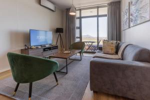 Axis Luxury Apartments by Century City Hotels في كيب تاون: غرفة معيشة بها أريكة وتلفزيون
