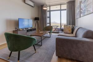Una sala de estar con un sofá y un televisor. en Axis Luxury Apartments by Century City Hotels, en Ciudad del Cabo