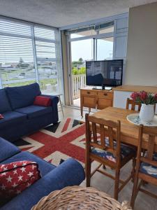 a living room with a blue couch and a tv at Bay Haven in Gansbaai