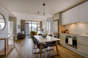 Una cocina y una sala de estar con mesa y sillas. en Axis Luxury Apartments by Century City Hotels, en Ciudad del Cabo