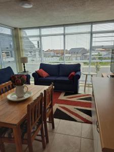 a living room with a table and a blue couch at Bay Haven in Gansbaai
