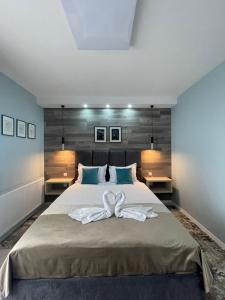 een slaapkamer met een groot bed en 2 witte handdoeken bij VOYAGE CUBIC Adults Only in Sibiu