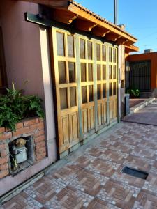 eine Holztür in einem Gebäude mit einem gemauerten Kamin in der Unterkunft POSADA DE KARMEL in Maipú