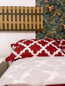 una cama con almohadas rojas y blancas encima en SOL- CARLOS V Apartaments, en Madrid