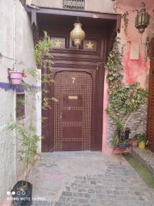 an entrance to a building with a large wooden door at Riad bel kayed in Fès