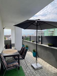 a patio with a table and chairs and an umbrella at VOYAGE CUBIC Adults Only in Sibiu