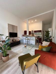 uma sala de estar com um sofá vermelho e uma cozinha em Karma Loft Barbizon - 40m2 em Barbizon