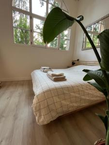 a bedroom with a bed in a room with windows at Karma Loft Barbizon - 40m2 in Barbizon