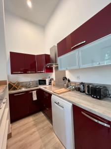 uma cozinha com armários roxos e electrodomésticos brancos em Karma Loft Barbizon - 40m2 em Barbizon