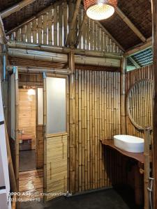 a bathroom with a toilet and a sink in a room at สวนเกษตรรักษ์ไผ่ Bamboo Conservation Farm in Surin