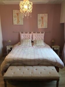 1 dormitorio con 1 cama grande y lámpara de araña en Chambre d'hôtes - La Pinstrie, 