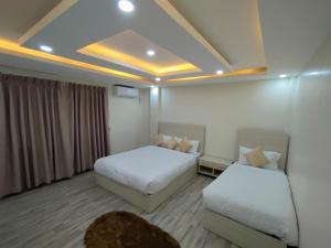 a hotel room with two beds and a couch at Thamel Central Apartment in Kathmandu