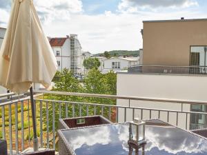 a balcony with an umbrella and a table and an umbrella at DünenResort Binz - Apt. 3.8 in Binz