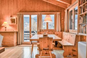 a dining room with a wooden table and a window at Chalet Arnica in Fiesch