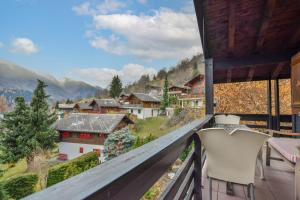 a balcony with a view of a town and mountains at Chalet Arnica in Fiesch