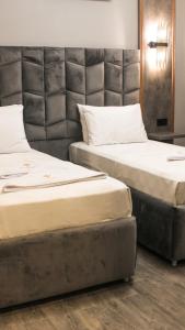 two beds sitting next to each other in a room at TALLES CITY HOTEL in Konak