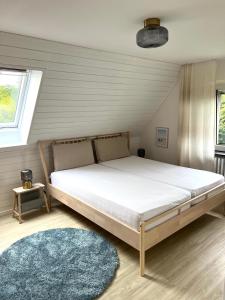 um quarto com uma cama grande e um tapete azul em Strandhaus Schilksee em Kiel