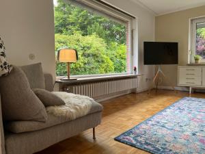 a living room with a couch and a large window at Strandhaus Schilksee in Kiel
