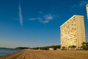 ein Gebäude an einem Strand neben dem Wasser in der Unterkunft Coconut Beach Boutique Studio in Platja  d'Aro