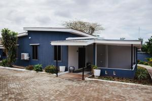 una casa azul con una entrada delante de ella en William Ofori-Atta Fie en Accra