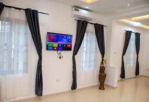 um quarto com cortinas pretas e uma televisão na parede em William Ofori-Atta Fie em Acra