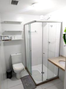a bathroom with a toilet and a glass shower at Apartamento JTR Maceió in Maceió