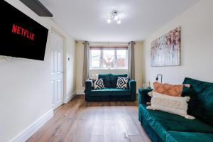 a living room with a green couch and a window at Charming 3-Bed cottage in Chester, ideal for Families & Workers, FREE Parking - Sleeps 7 in Chester