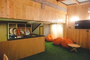 een kamer met oranje kussens, een tafel en een televisie bij Double Five in Bangkok