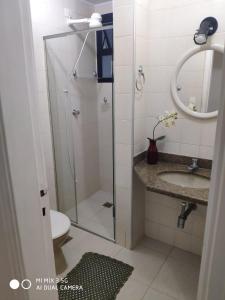 La salle de bains est pourvue d'une douche, d'un lavabo et de toilettes. dans l'établissement Apartamento amplo a menos de 400 metros da praia localizado próximo a praça da Brunella, área nobre do Guarujá., à Guarujá