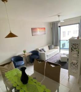 uma sala de estar com um sofá e uma mesa em Apartamento amplo a menos de 400 metros da praia localizado próximo a praça da Brunella, área nobre do Guarujá. no Guarujá