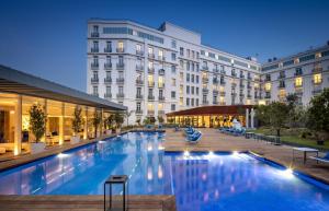 une grande piscine en face d'un bâtiment dans l'établissement Hôtel Martinez, in The Unbound Collection by Hyatt, à Cannes