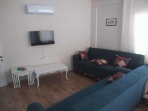 sala de estar con sofá azul y mesa en Kaptan Apart-1 Fethiye Karagözler Evinizden uzak eviniz, en Fethiye