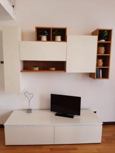 una sala de estar blanca con TV en una mesa blanca en Il Nido Bilocale Niguarda, en Milán