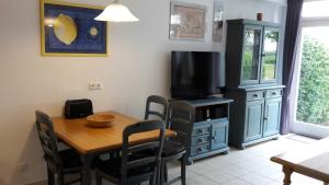 a dining room with a table and a television at Landhaus am Haff_ Wohnung B 8 in Stolpe auf Usedom