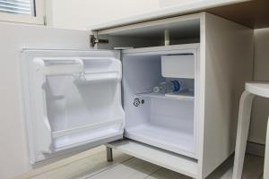 - un réfrigérateur blanc avec une porte ouverte dans la cuisine dans l'établissement Time B&B, à Poggiomarino