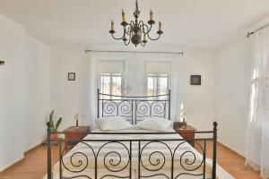 a bedroom with a bed with a chandelier at Casa Cânda in Sălaşu de Sus