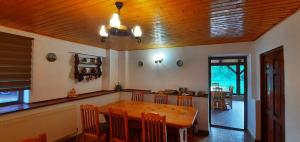 a dining room with a wooden table and chairs at Casa Cânda in Sălaşu de Sus