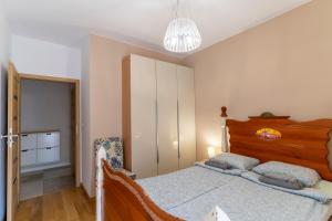 Schlafzimmer mit einem Bett und einem Kronleuchter in der Unterkunft FIRST -- Green Żoliborz apartment 1 in Warschau